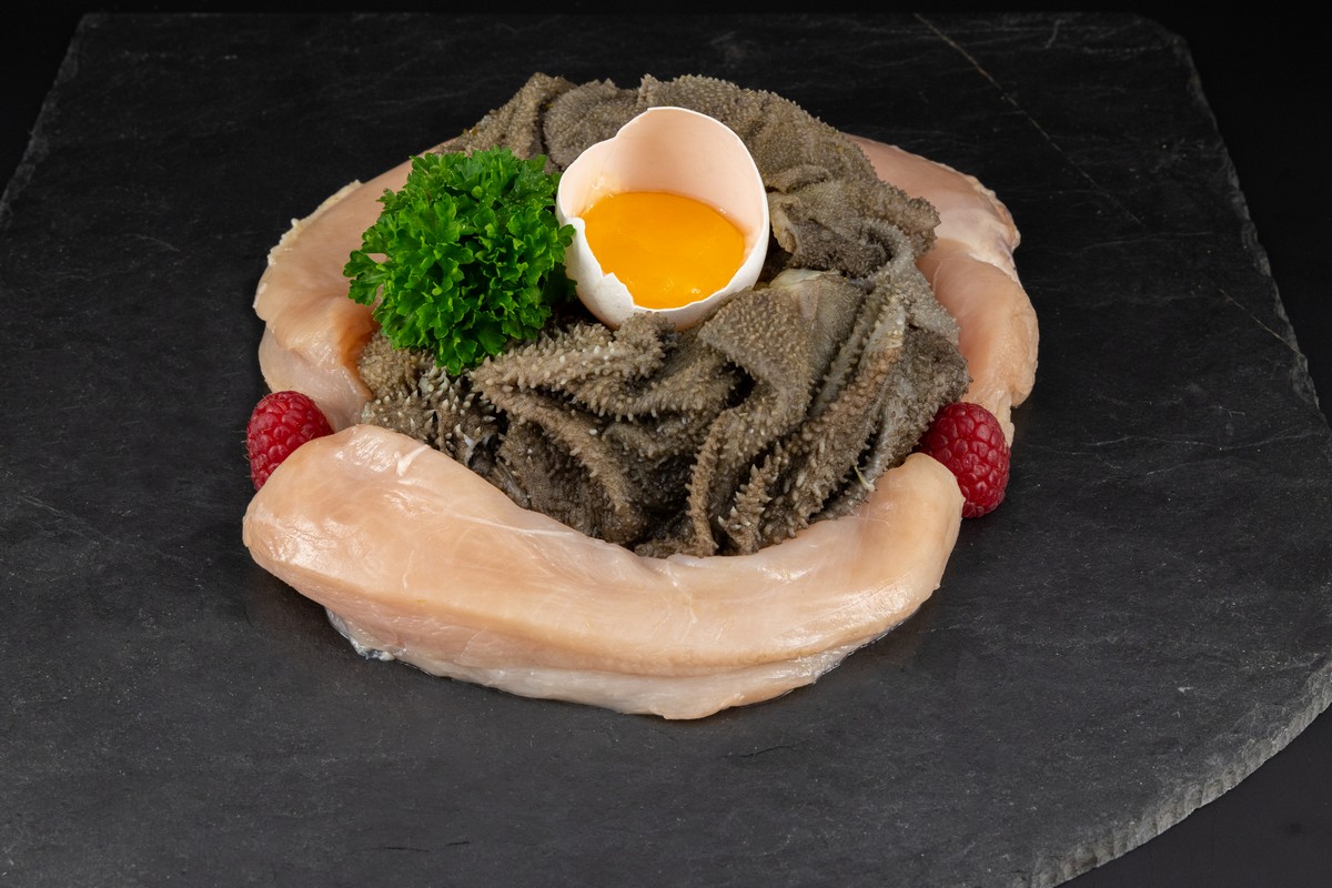 Barf_Hund_Futter_Pansen Fleisch in Form eines Ring gelegt. Darin Pansen trpiert und in der Mitte ein Eigelb in der Eierschale plaziert